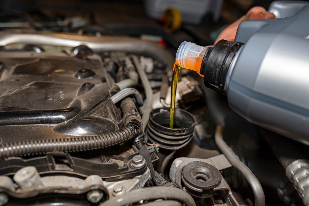 car-mechanic-pours-new-car-oil-into-the-engine